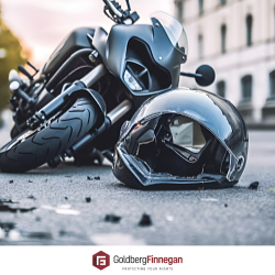 A helmet sits on the ground next to a motorcycle after an accident